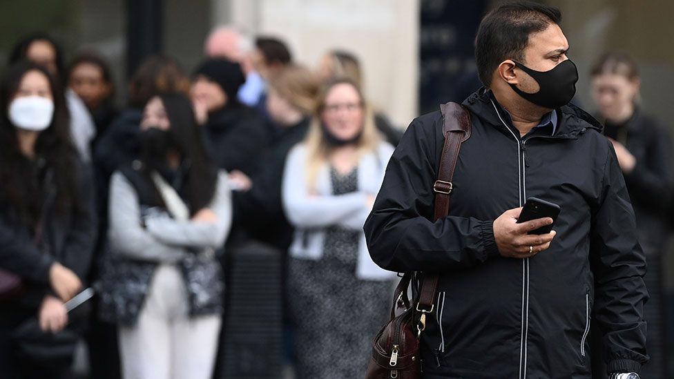 Man wearing a mask crossing the road in London