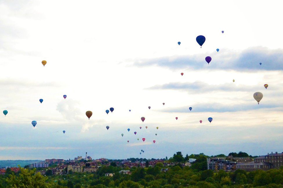 Hot air balloons fly overhead