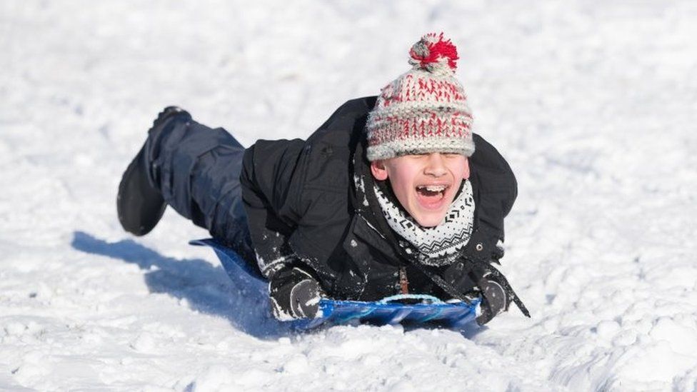A child sledging in the snow