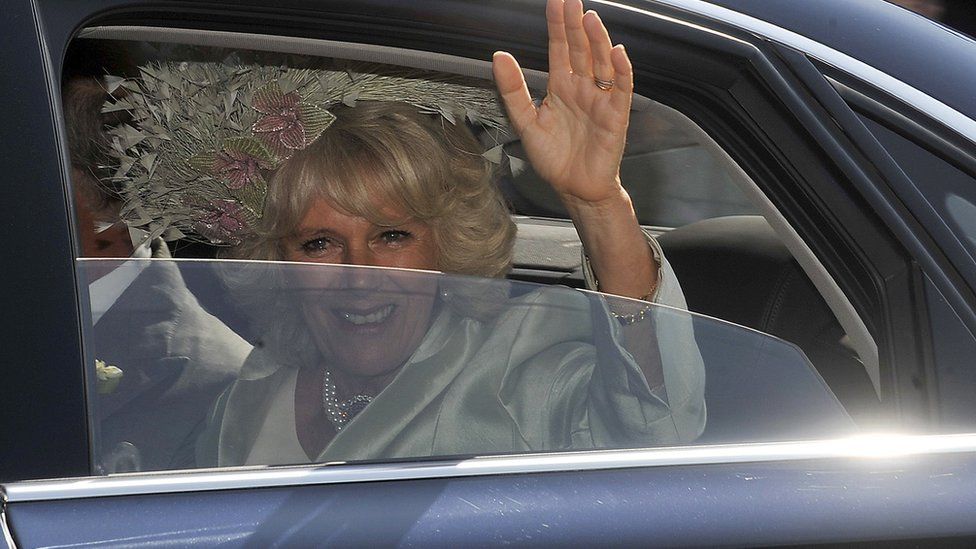 Camilla, the Duchess of Cornwall, waves as she drives along the Royal Mile to Holyrood House after the wedding between England rugby player Mike Tindall and Britain's Zara Phillips, granddaughter of Queen Elizabeth II, at Canongate Kirk in Edinburgh, Scotland, on July 30, 2011.