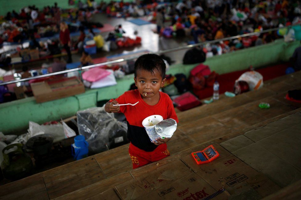 A child eats noodles at a temporary evacuation centre for people living near Mount Agung, a volcano on the highest alert level, inside a sports arena in Klungkung, on the resort island of Bali, Indonesia, 24 September 2017.