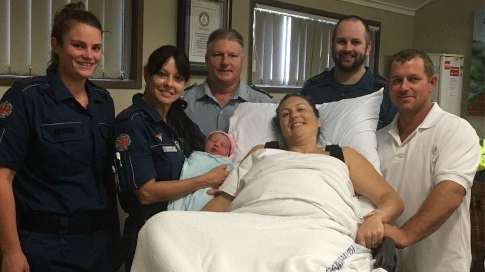 Billiana with her parents and the paramedics who delivered her