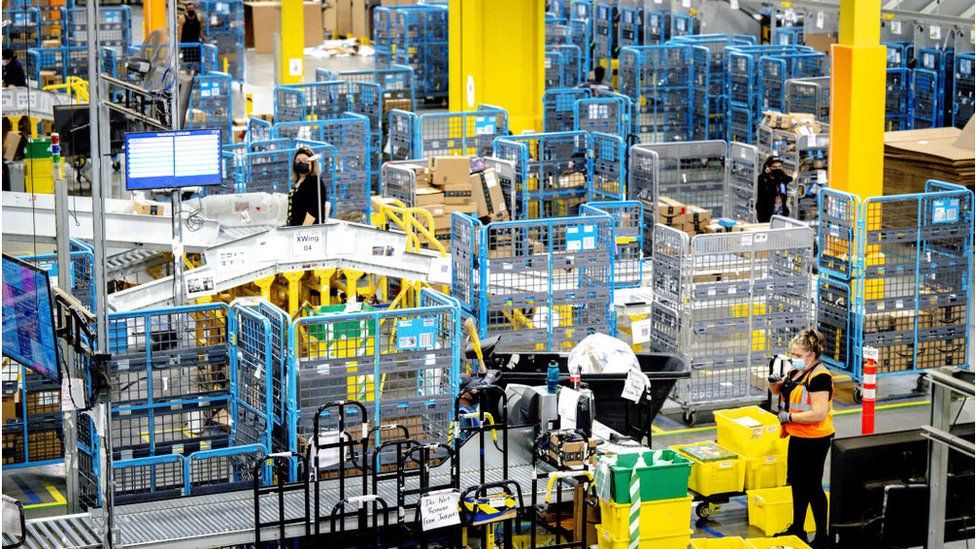 Workers sort out parcels in the outbound dock at Amazon fulfillment center in Eastvale