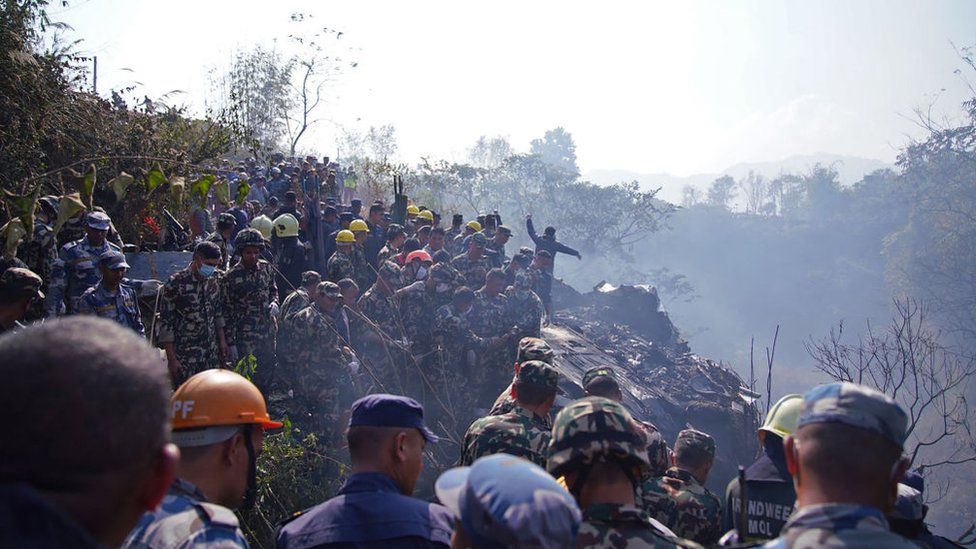 Rescuers gather at the site of a plane crash in Pokhara
