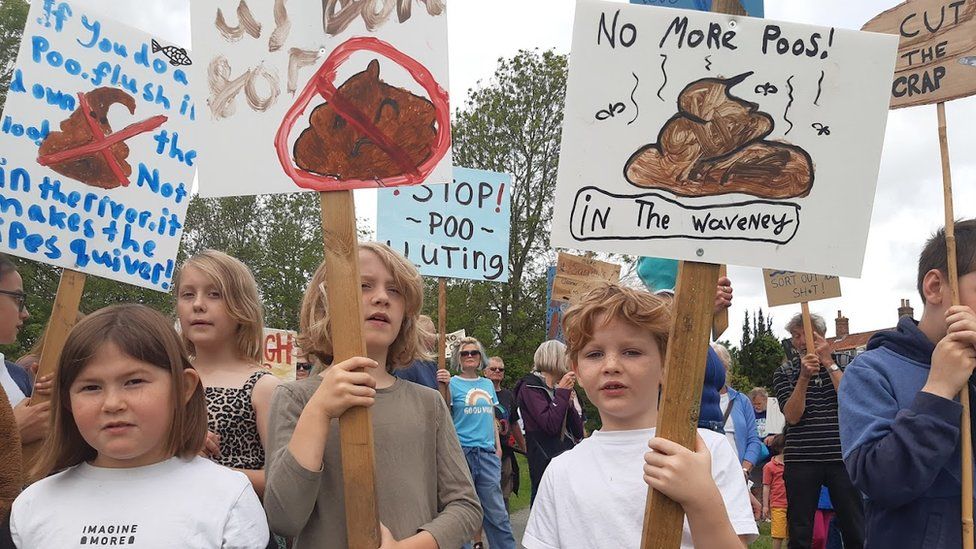 Children with placards at a Procession Against Poo, in Bungay, Suffolk