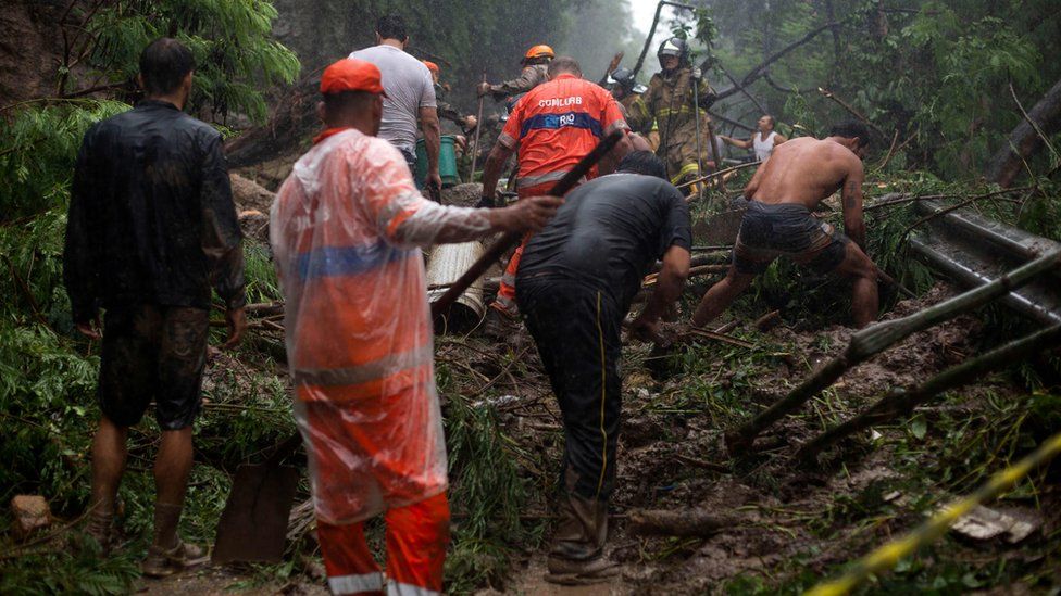 Firefighters and volunteers take part in a rescue operation after a mudslide