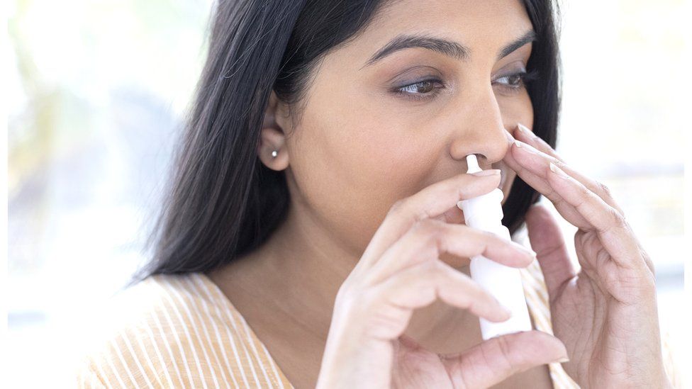 Woman using a nose spray