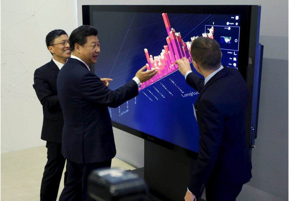 Chinese President Xi Jinping (C), Microsoft's Harry Shum (L) and David Brown (R) take part in a demonstration of how Microsoft Surface technology can be used for data visualization during Xi's tour of Microsof's main campus in Redmond, Washington 23 September 2015