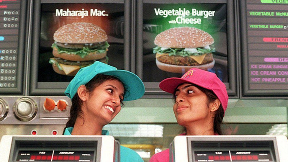 Two employees stand behind the counter of the first McDonald's fast-food restaurant in New Delhi, India, October 11, 1996.