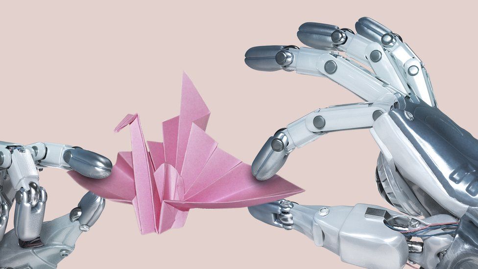Две руки робота нежно манипулируют бумажным журавликом оригами
