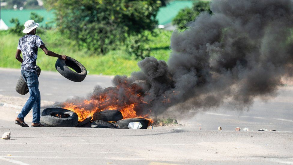 A protesters burns tyres on a road during a "stay-away" demonstration against the doubling of fuel prices