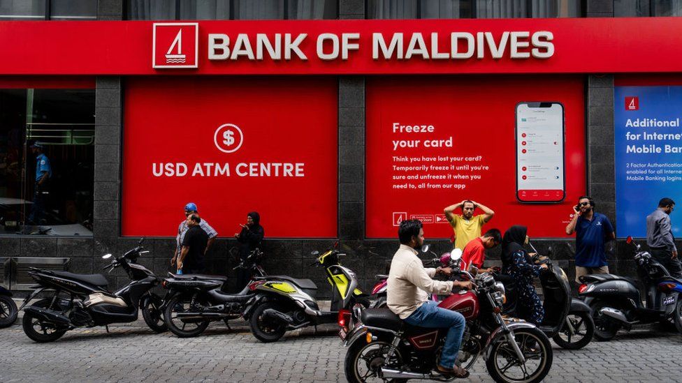 People conduct business and stand outside of the bank of Maldives during the daily life in Male, Maldives on December 05, 2023.