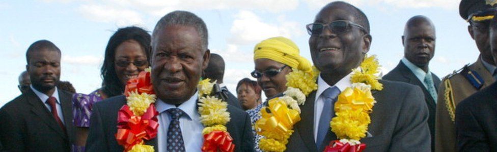 Robert Mugabe (R) welcomes Zambian President Michael Sata (L) upon his arrival in Harare on April 25, 2012 for a two-day state visit