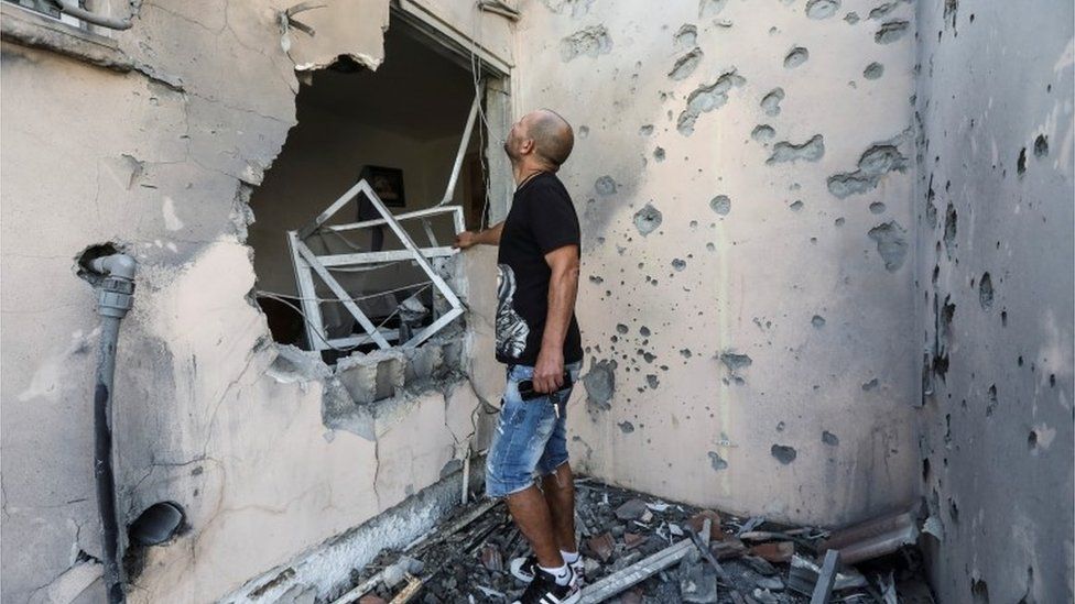 Израильтянин в Сдероте осматривает ущерб, нанесенный ракетой, выпущенной из Газы (20.05.21)