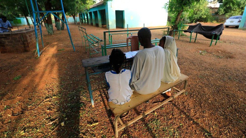 A teacher sits with students at a school for girls in Burri, in the eastern part of the Sudanese capital Khartoum, on September 14, 2022