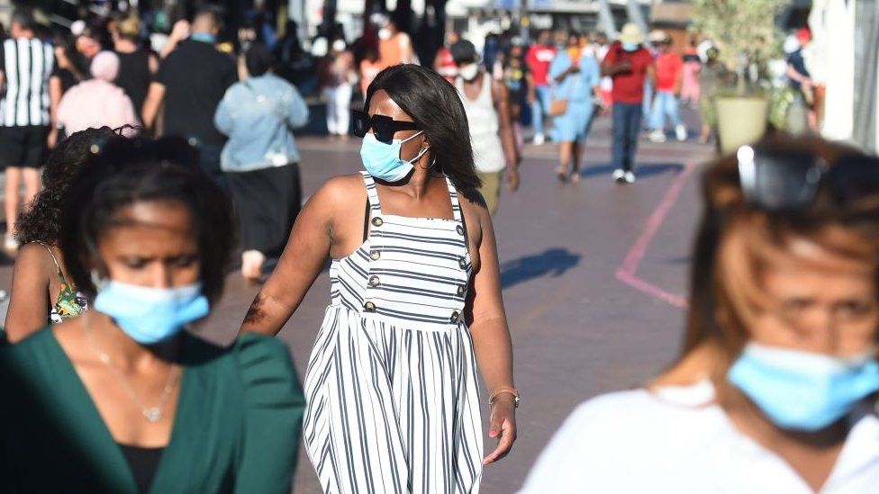 People wearing face masks walk in Cape Town, South Africa on December 27, 2020
