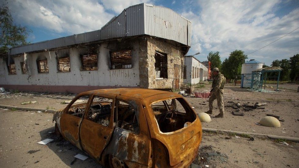 Ukraiński żołnierz sprawdza obszar uszkodzony przez rosyjski atak wojskowy, gdy trwa atak Rosji na Ukrainę, w mieście Mariinka, w obwodzie donieckim na Ukrainie 28 maja 2022 r.