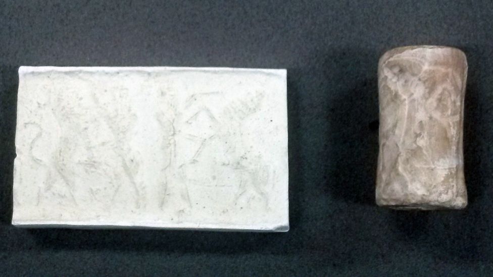 A stone cylinder and a slab with an impression