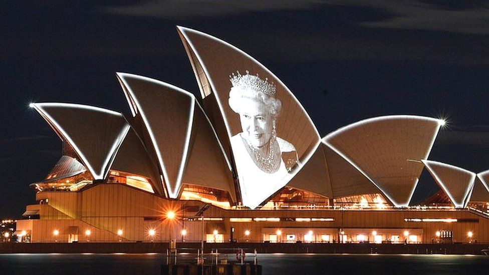 Image shows Sydney Opera House with image of Queen