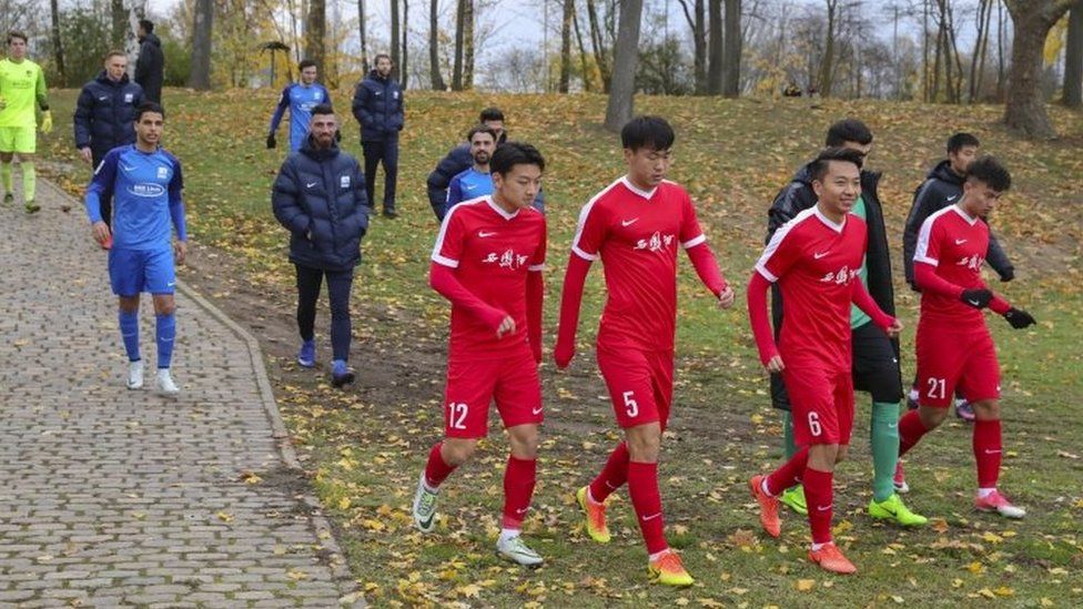 China's U20 players (in red) returned to the pitch in Mainz after Tibetan flags are removed. Photo: 18 November 2017
