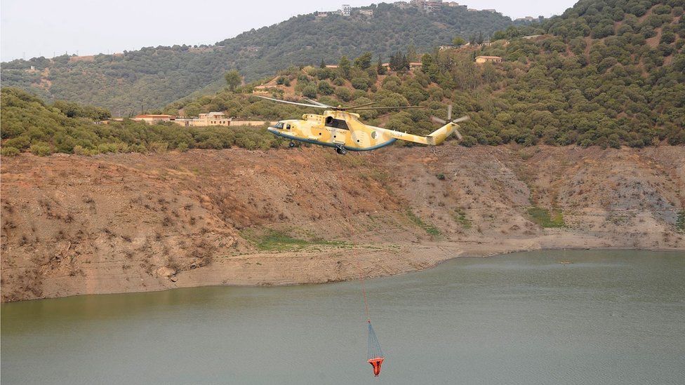 Алжирский вертолет гражданской защиты работает над тушением пожара в деревне Бен-Дуала недалеко от Тизи-Узу, в горном районе Кабиле, в 100 км к востоку от Алжира, Алжир, 12 августа 2021 г.
