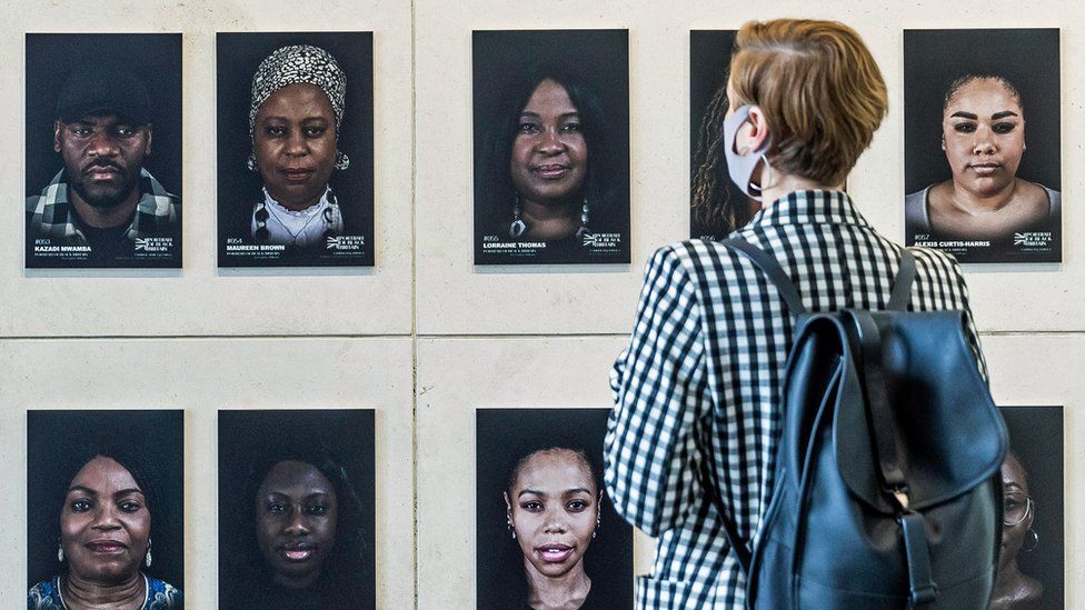 Person looking at images from Portrait of Black Britain exhibition at Manchester's Arndale Centre