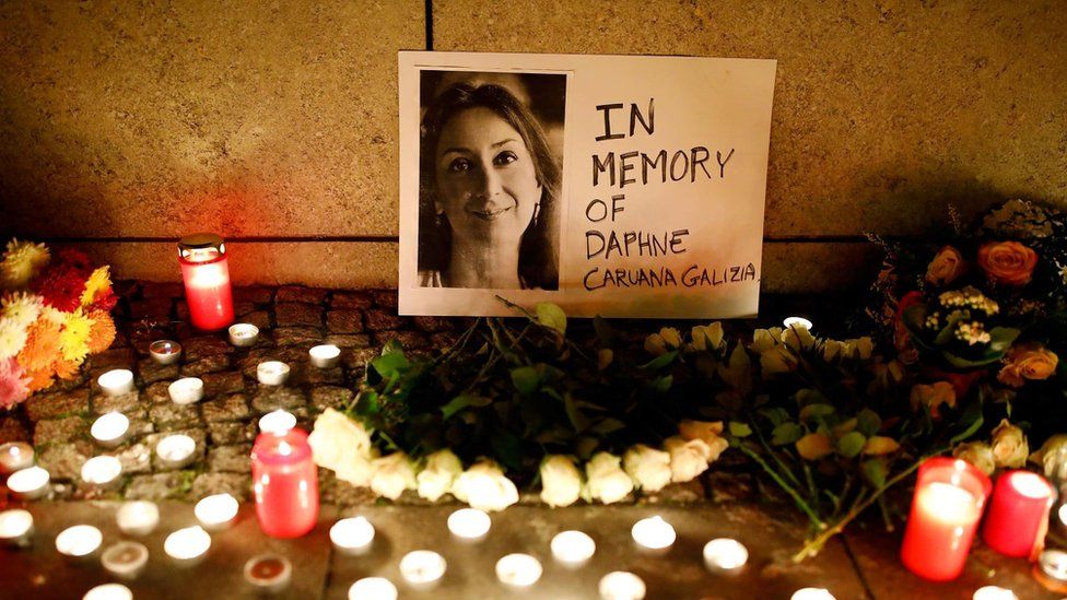 Photo of Daphne Caruana Galizia with small memorial candles lit in front.