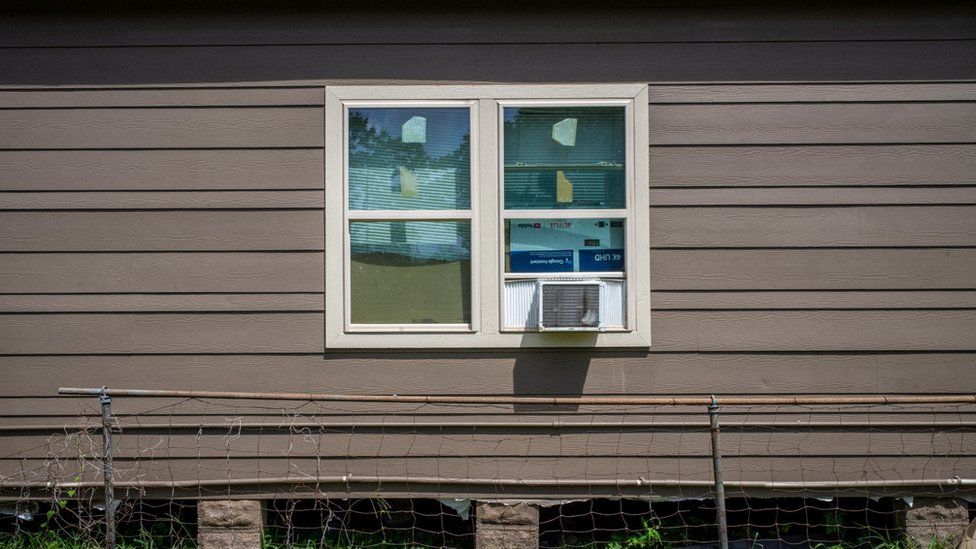 A house with windows boarded by cardboard