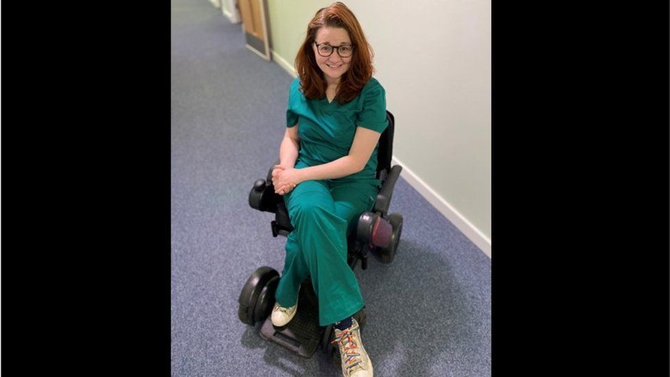 Dr Hannah Barham-Brown in her wheelchair and scrubs