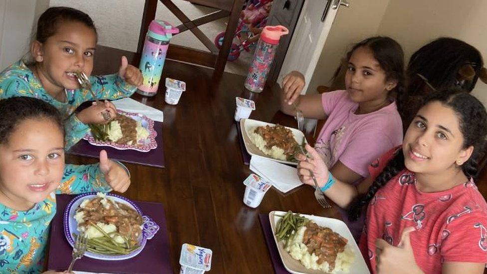 The Andu sisters enjoying a meal made with their food hamper