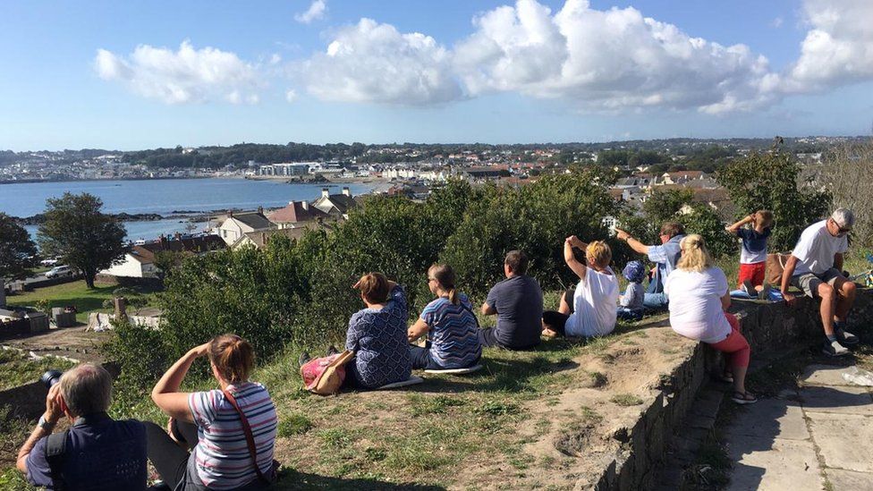 People sat overlooking Guernsey bay