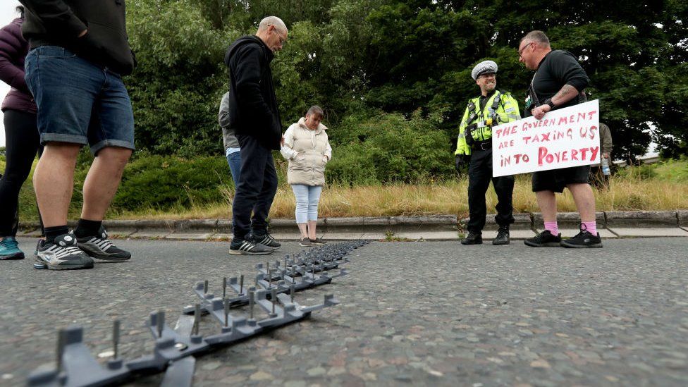 Protesters talk to the police after they deployed a stinger on the exit junction at Ferrybridge services