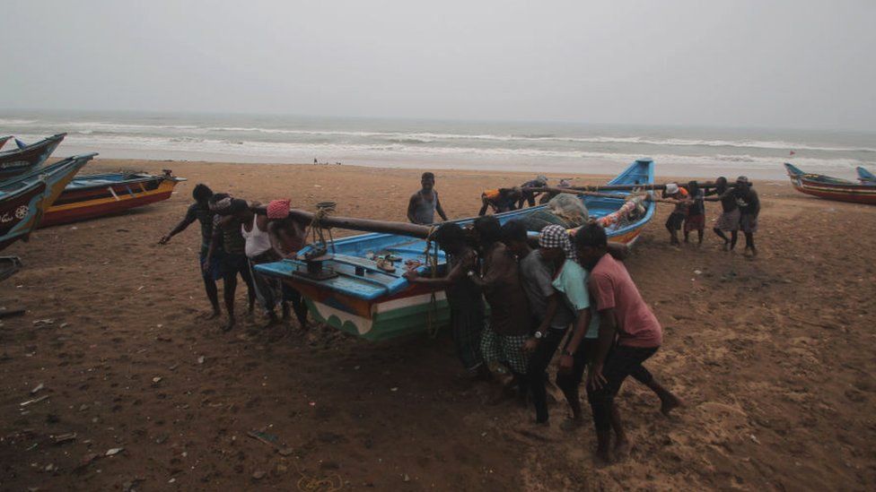 Fishermen move their fishing boats to safety in preparation for Cyclone Yaas