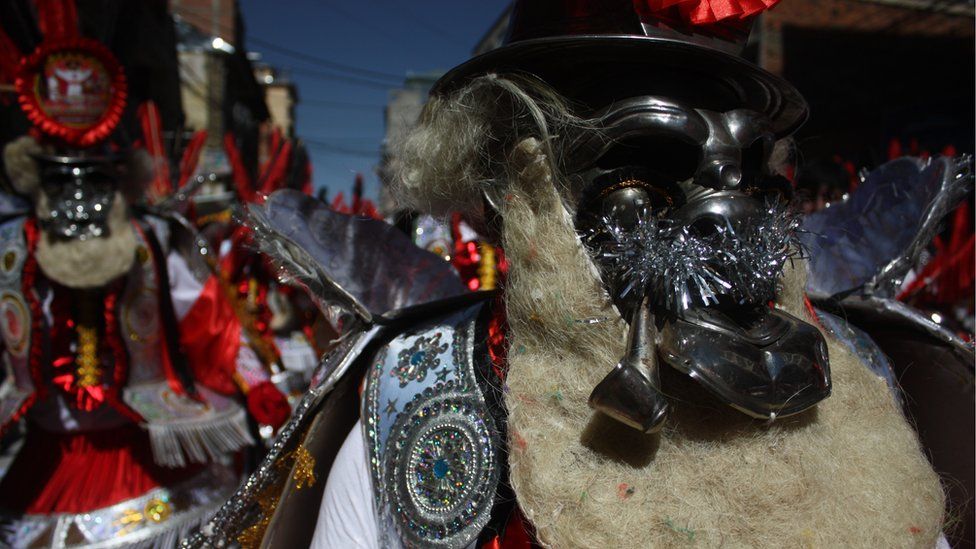 A dancer wears an elaborate mask during the Lord of the Great Power parade in La Paz