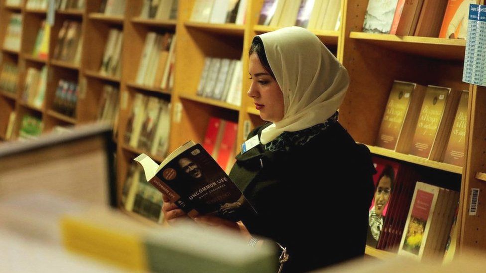 File photo showing a woman reading a book on a floating book fair docked at Port Said in Egypt (5 January 2023)