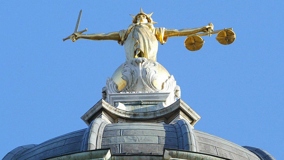 The statue of justice stands on the copula of the Old Bailey courthouse