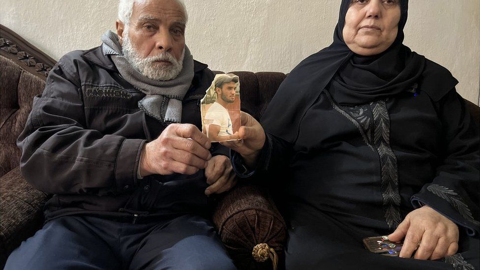 Махди и Умм Саиф держат фотографию своего сына Бакра