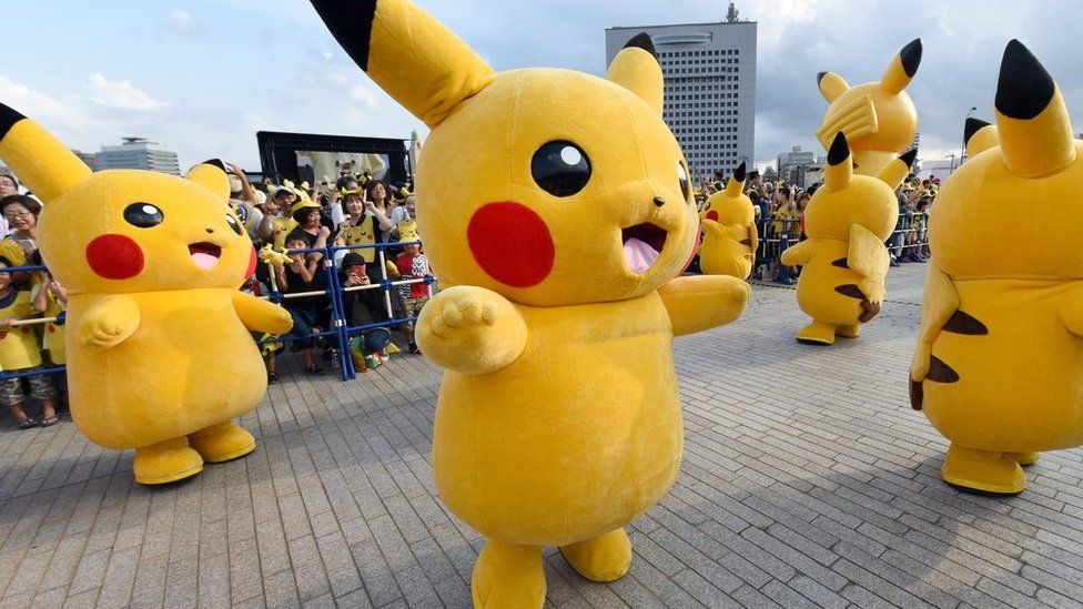 people in Pikachu costumes onstage in Japan