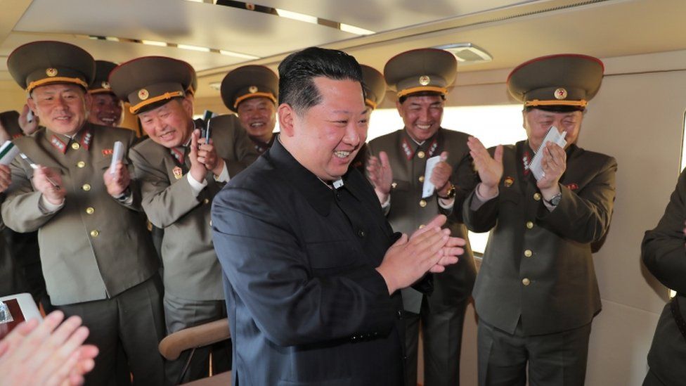 North Korea's leader Kim Jong-un claps as he watches the test-fire of a new type of nuclear weapon at an undisclosed location on 17 April