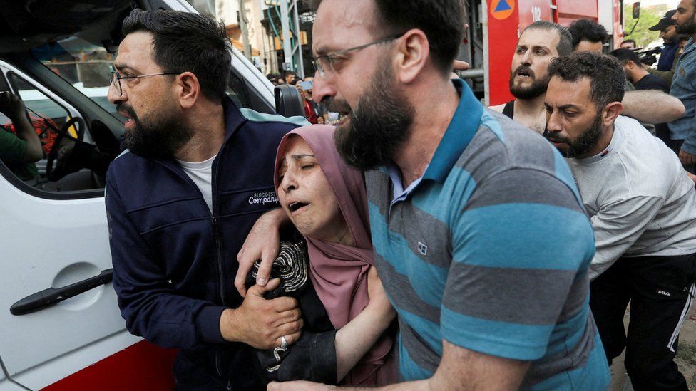 People react following an Israeli strike that killed senior Islamic Jihad commander Iyad al-Hassani in Gaza City (12 May 2023)