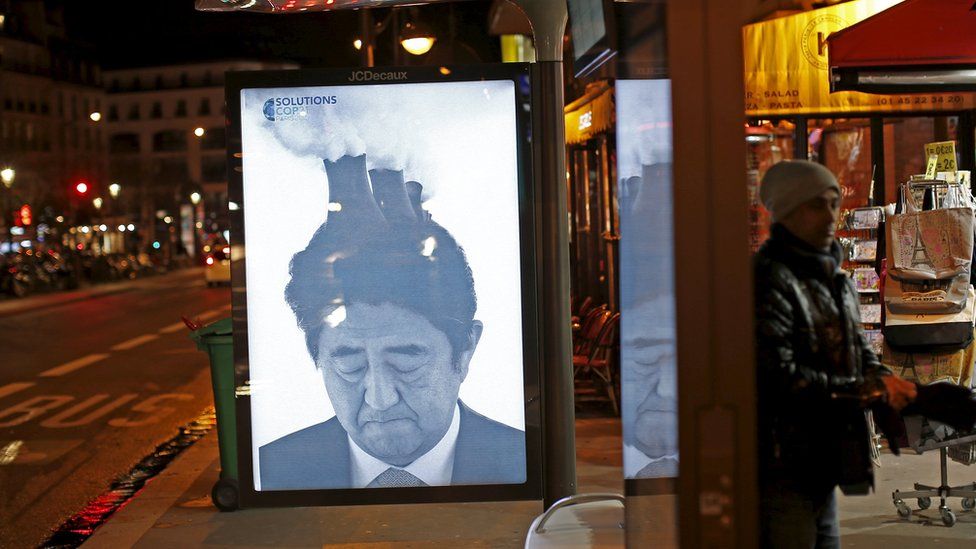 Japan Prime Minister Shinzō Abe featured with factory towers and billowing smoke coming out of his head