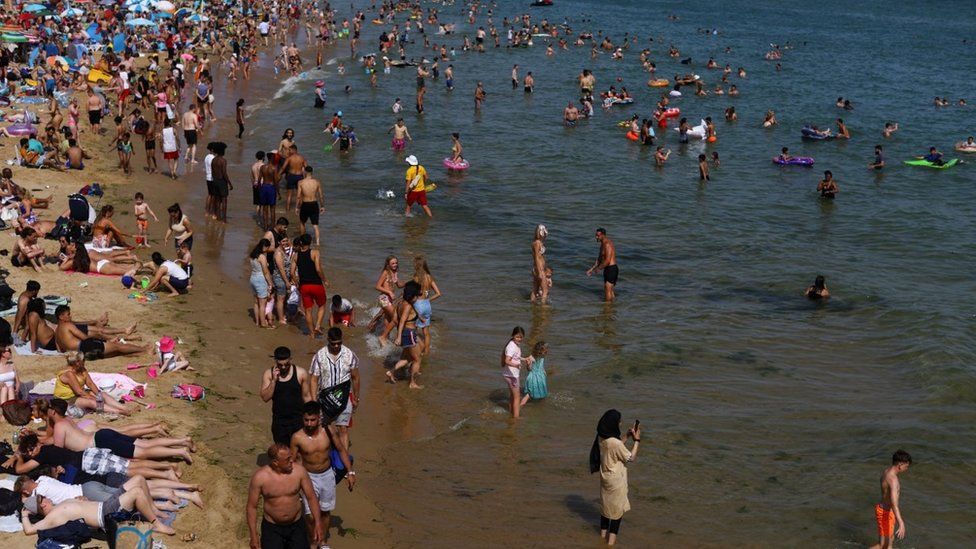 People and children enjoy the hot weather at Bournemouth Beach on June 17