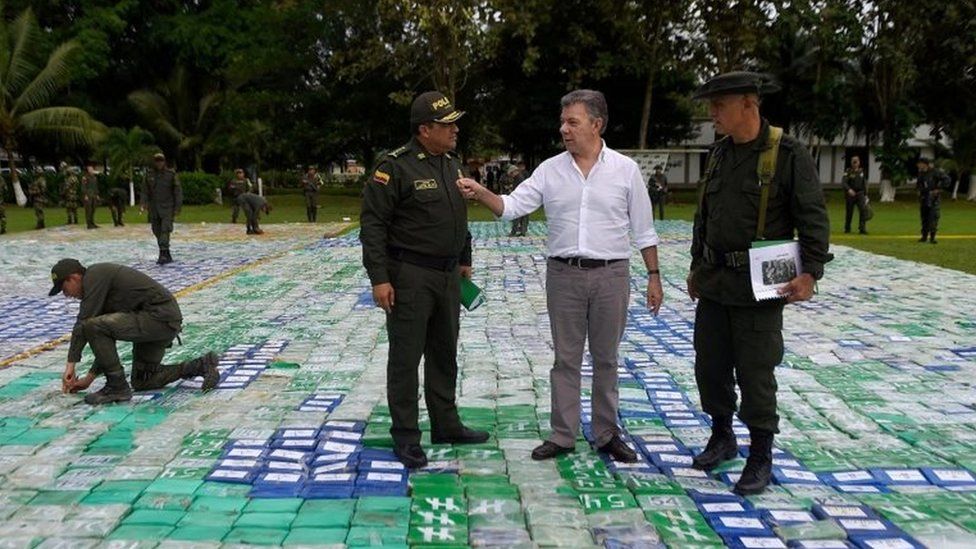 A handout photo made available by the Presidency of Colombia shows the Colombian President Juan Manuel Santos (2R) in the middle of packages containing cocaine, in Apartado, in the Department of Antioquia, Colombia, 08 November 2017