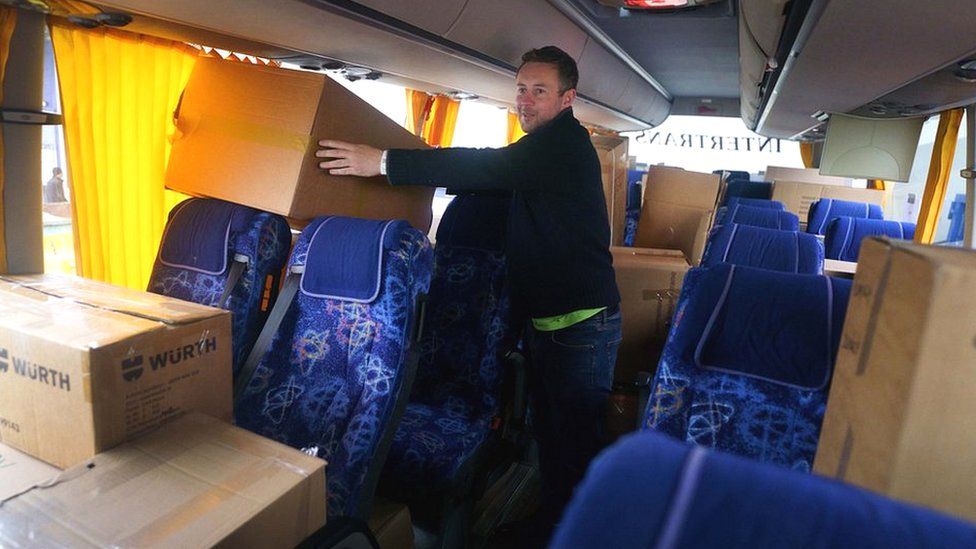 British volunteer Cliff Wilson loads aid supplies onto his bus to transport it to Ukraine