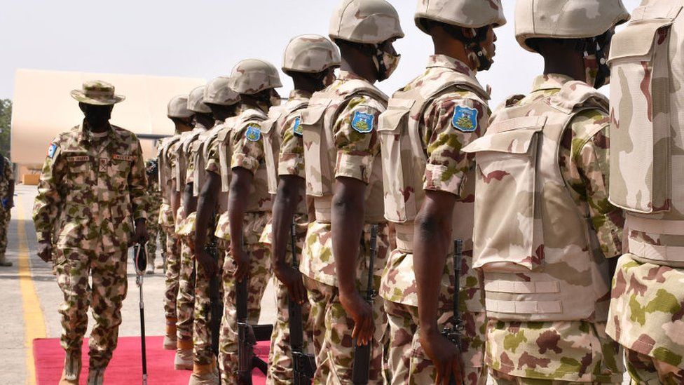 Chief of Defence Staff Major General Leo Irabor (L) inspects soldiers standing on attention during a guard of honour
