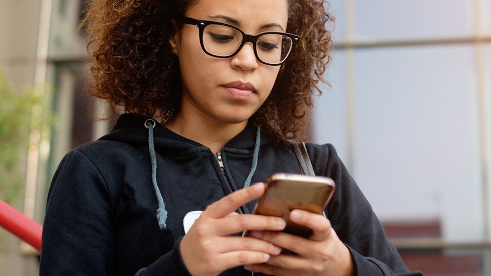 Young woman looking at her mobile phone