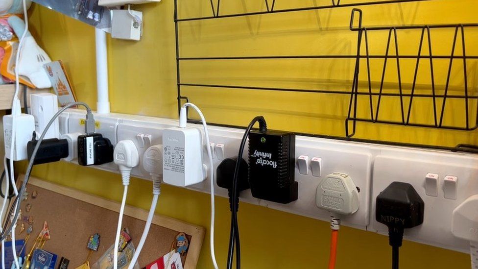 A dozen cords plugged into a power board in Michaela's room