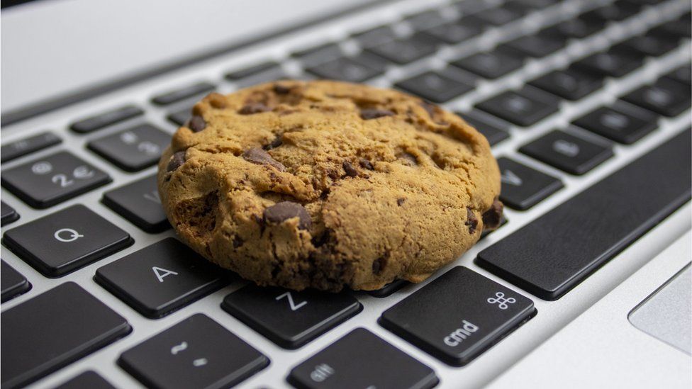 A chocolate chip cookie on a keyboard