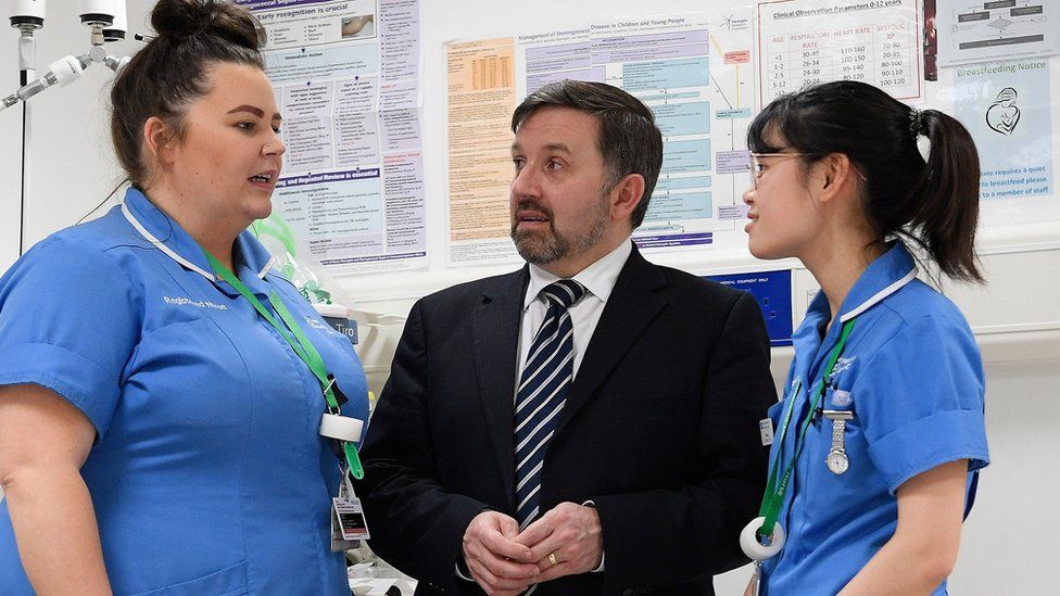 Health Minister Robin Swann (centre) with Staff Nurses Amber Loung (right) and Gillian Browne, during a visit to the emergency department of the Ulster Hospital in Dundonald in January