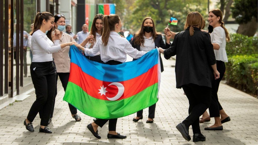 People take part in celebrations in a street following the signing of a deal to end the military conflict over the Nagorno-Karabakh region in Baku